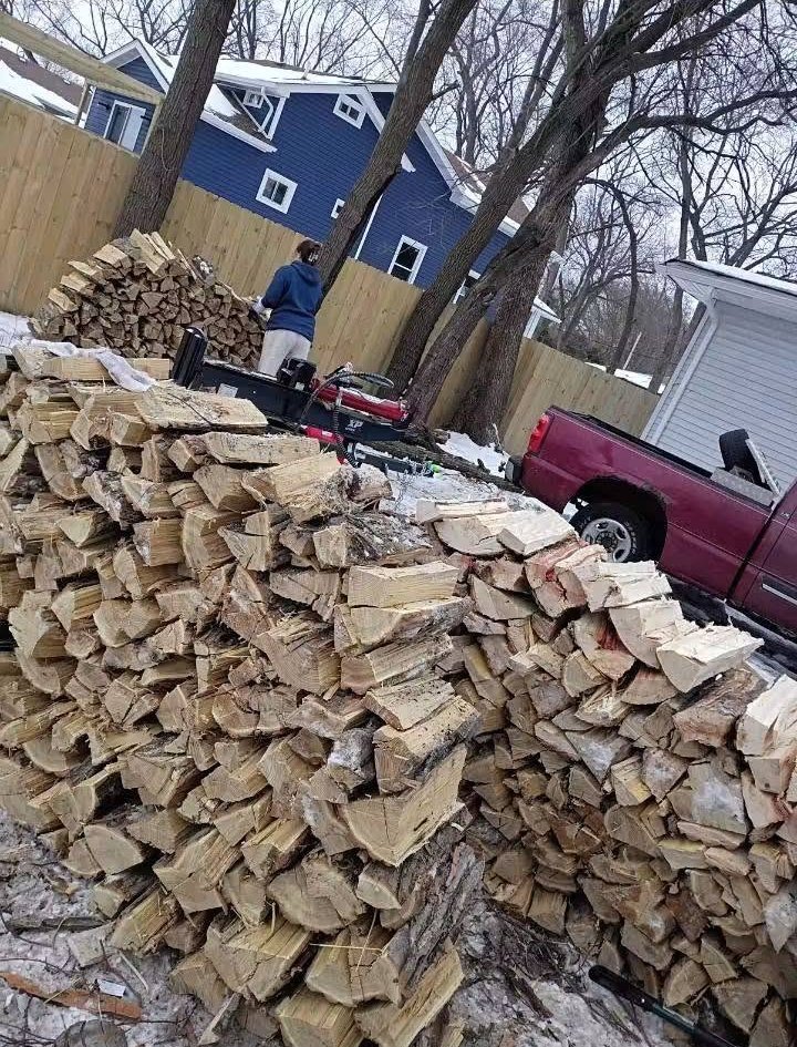 Big piles of fresh split firewood next to the truck